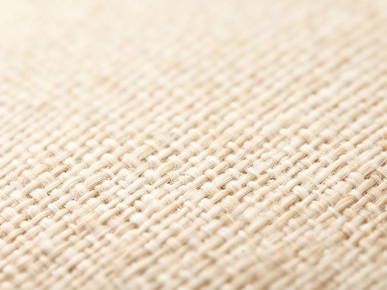Dichtes Leinwandgewebe in heller Naturfaseroptik mit fein sichtbarer, regelmässiger Struktur